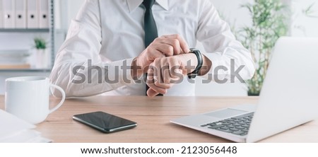 Checking time, impatient businessman waiting scheduled meeting and looking at his wristwatch in the office, selective focus Royalty-Free Stock Photo #2123056448