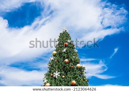 Christmas tree with balls and blue sky on background
