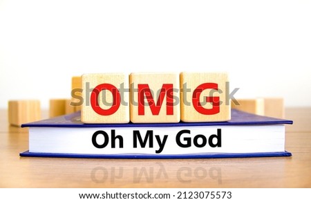 OMG oh my god symbol. Concept words OMG oh my god on wooden cubes on book on a beautiful wooden table, white background. Business and OMG oh my god concept. Copy space.