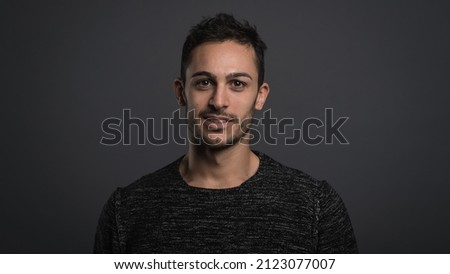 Smiling confident man close up portrait against dark grey background.
