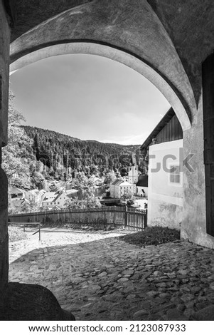 View of Rozmberk nad Vltavou town through gate, Czechia. Black and white photography