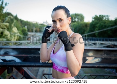 portrait young Caucasian woman boxer on a bridge over railroad tracks