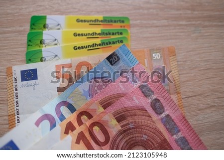 10, 50 euro banknotes, electronic public health insurance cheaper, Insurance Card in German, concept medical support on trip to Europe, guarantee of treatment, payments to medical fund Royalty-Free Stock Photo #2123105948