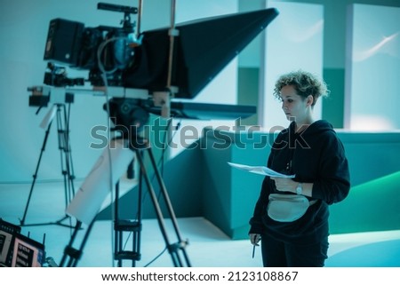 Director at work on the set. The director works with a group or with a playback while filming a movie, advertising, or a TV series. Shooting shift, equipment and group. Modern photography technique. Royalty-Free Stock Photo #2123108867