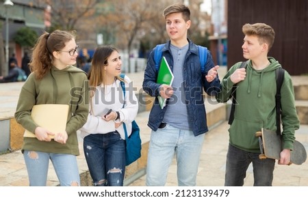 Teenage students spending time together after lessons, talking and having fun outdoors Royalty-Free Stock Photo #2123139479