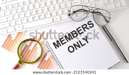 MEMBERS ONLY text written on notebook with keyboard, chart,and glasses