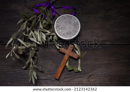 Bowl with ashes, olive branch and cross, symbols of Ash Wednesday Royalty-Free Stock Photo #2123142362