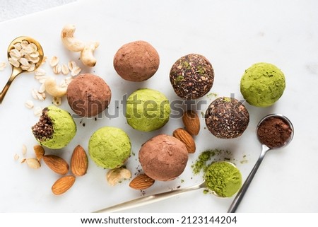 Variety of homemade vegan energy balls with cocoa and green tea matcha