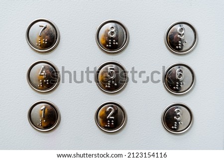 A close shot of the elevator buttons. Housing and communal services. Minimalistic design. Font for the blind. Go up to the floor by elevator. High quality photo