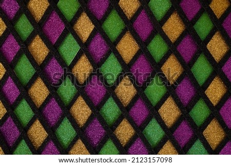 Shiny green, purple and golden glittering paillettes diamonds fabric. Mardi Gras holiday background.