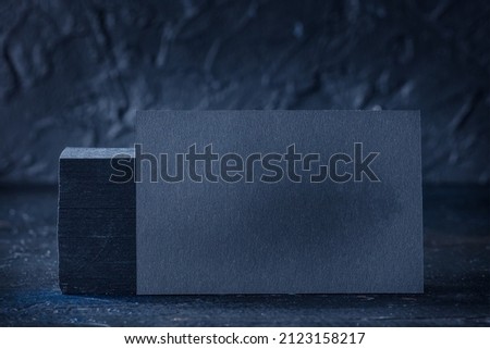 Black business card mock-up on a black slate background, a template for design presentation, thick cardboard