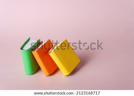 three books stand on a light background, copy space