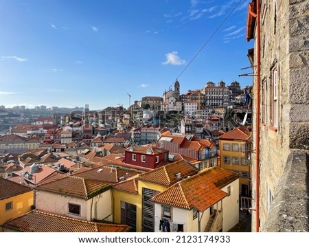 Stunning view of the Porto old town from above, red and orange tiled roofs and colorful old houses on a sunny day