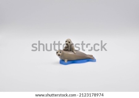 two seals on an ice floe.isolated background.space for text.plastic toy.