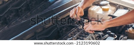 Banner Man hands fixing Car machinery vehicle mechanical service. Mechanic man hands repairing car shop. panoramaopen vehicle hood checking up auto mobile. Car maintenance engineer with copy sapce. Royalty-Free Stock Photo #2123190602