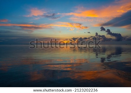 Beautiful sunset over the sea water on the island Koh Phangan, Thailand. Travel and nature concept. Evening sky, clouds, sun and sea water. Wonderful cloudscape over the sea