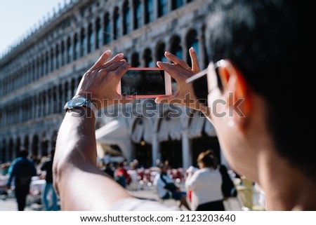 Cropped female tourist using cellular camera for photographing ancient architecture buildings during summer vacations in Venice, woman shooting travel video vlog on modern smartphone technology