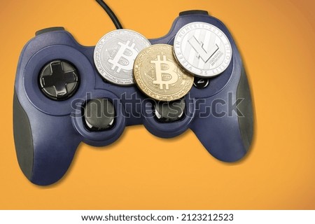 Crypto gaming concept. Video game controller with a bitcoin cryptocurrency golden coin Royalty-Free Stock Photo #2123212523