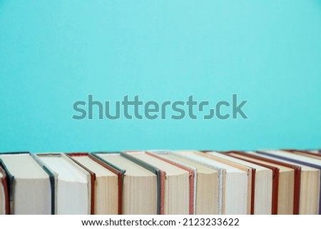 Composition with vintage old hardback books, diary, fanned pages on wooden deck table and colored background. Books stacking. Back to school. Copy Space. Education background.