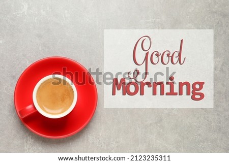 Good Morning. Aromatic coffee in red cup on light grey background, top view