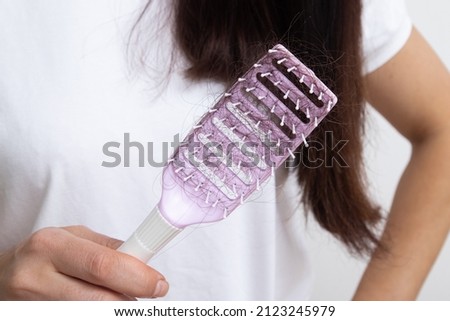 Comb with lost female hair. Tangled and falling out hair, care for long hair.