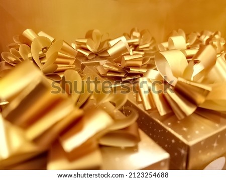 Golden gift boxes in gold wrapping paper with ribbon and bow Royalty-Free Stock Photo #2123254688