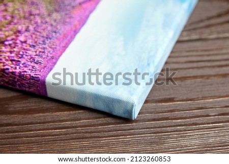 Canvas photo print stretched onto frame on wooden background