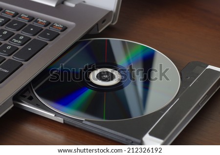 Installing program from DVD to laptop computer Royalty-Free Stock Photo #212326192