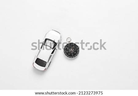 Toy car with compass on white background. Travel concept. Top view