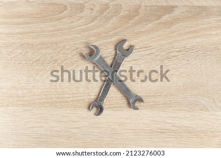 Metallic wrenches on a wooden table. Top view