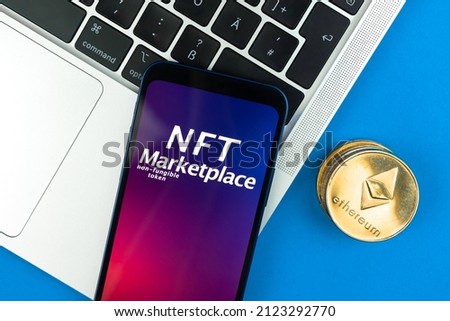 NFT cryptoart marketplace concept. Mobile phone for working with non-fungible token. Future of crypto currency, blockchain technology. Office table with laptop and ethereum coin, top view