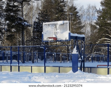 Basketball backboard with hoop in snow and sports ground in winter season, Yaroslavl, Russia
