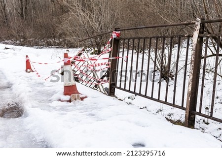 A car accident hit a bridge railing in snowy winter day. White and red ribbon.