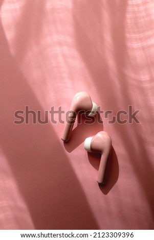 Pink earphones on pink background. Flat lay.