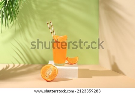 Modern still life with citrus fruits, orange juice and oranges on a pastel background with long hard shadows, minimal detox diet concept, summer vitamin drinks, selective focus, Royalty-Free Stock Photo #2123359283