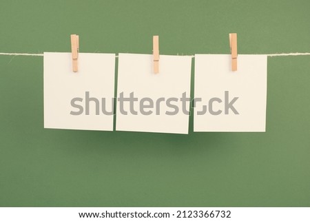 Empty white sheets of paper in a row hanging on a string, copy space for pictures and text, message communication and marketing background