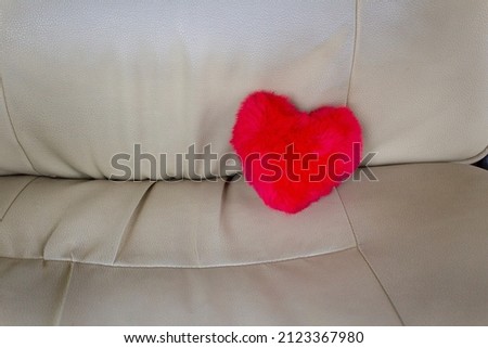 Red heart on light beige chair 