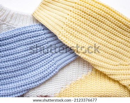 Knitted sweater close-up. Multi-coloured sleeves and neck of a knitted sweater.