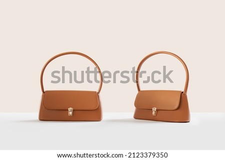 Beautiful brown leather female fashion bag isolated on light beige background, front view Royalty-Free Stock Photo #2123379350
