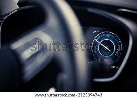 Close up shot of a digital dashboard of a new car, showing power and charge. 