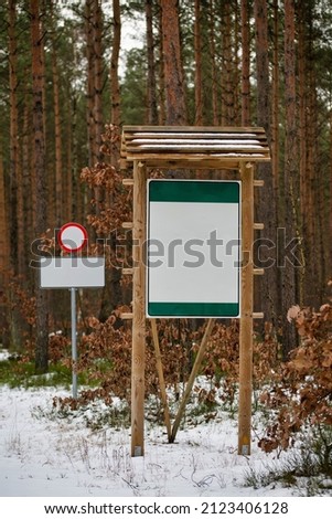 Empty boards and signs set by the forest road. 