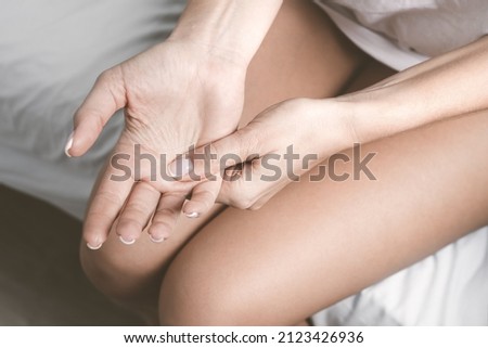 Hand numbness or limb numbness. Woman with hand pain and finger pain after sleep Royalty-Free Stock Photo #2123426936