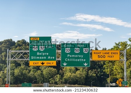 Road signs in Athens, Ohio on Route US 33 for Exit 197 A-B for Belpre, Stimson Ave and continuing on Routes US 33, US 50 and Ohio 32