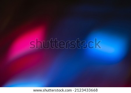 Blur neon light. Lens flare overlay. Bokeh fluorescent flash gleam. Defocused blue magenta pink color flecks on dark black abstract background.