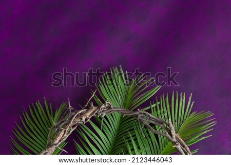 Crown of thorns and palm leaves border on a dark purple background with copy space