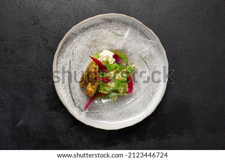 Zucchini fritters with fish ceviche and cheese cream. Healthy food - vegetables fritters and fish tartar. Inspirational chefs food on dark background. Modern food. Contemporary menu for restaurant