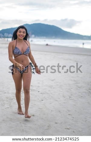 Brazilian woman on a beach in summer in a bikini