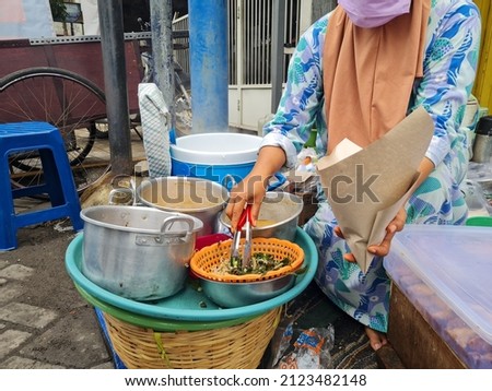 Street vendors in Indonesia, pecel sellers serve buyers and trade on the roadside. local indonesian street food Royalty-Free Stock Photo #2123482148