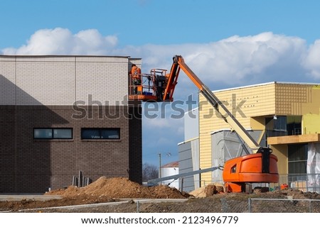 Man worker in a boom lift, machine control on the aerial platform industry crane