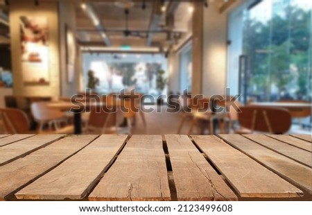 Wooden table top on blur restaurant or cafe background.For montage product display or design key visual layout.View of copy space.